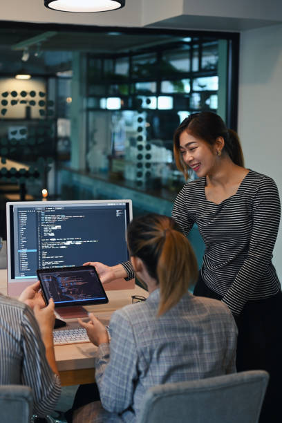 Female project supervisor explaining detail of project developing website design and coding technologies at creative office.